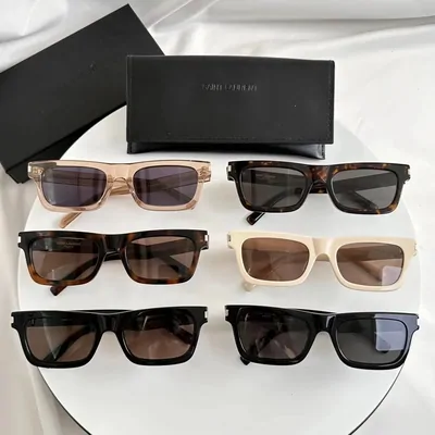Six pairs of rectangular sunglasses on a white dish, in tortoiseshell, cream and black, with a hard case behind them